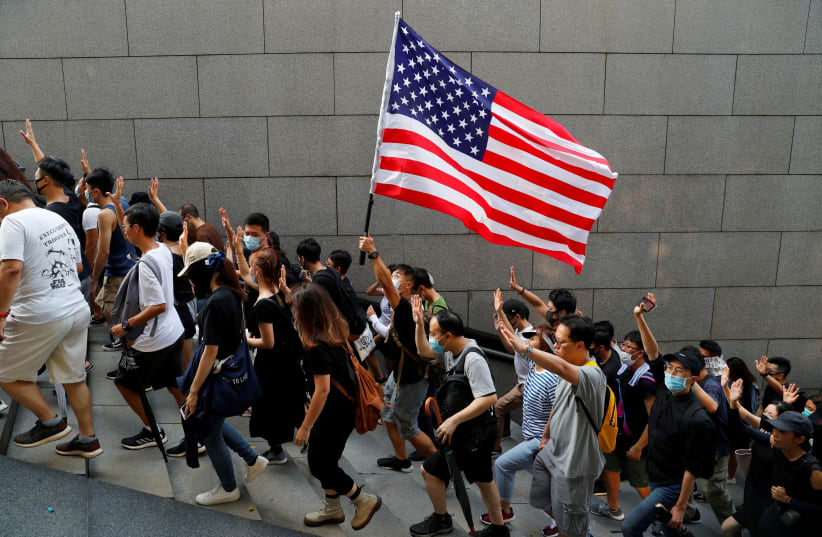 Protesters hold up five fingers and a U.S. flag during a rally to the U.S. Consulate General in Hong Kong, China September 8, 2019. (photo credit: REUTERS/ANUSHREE FADNAVIS)