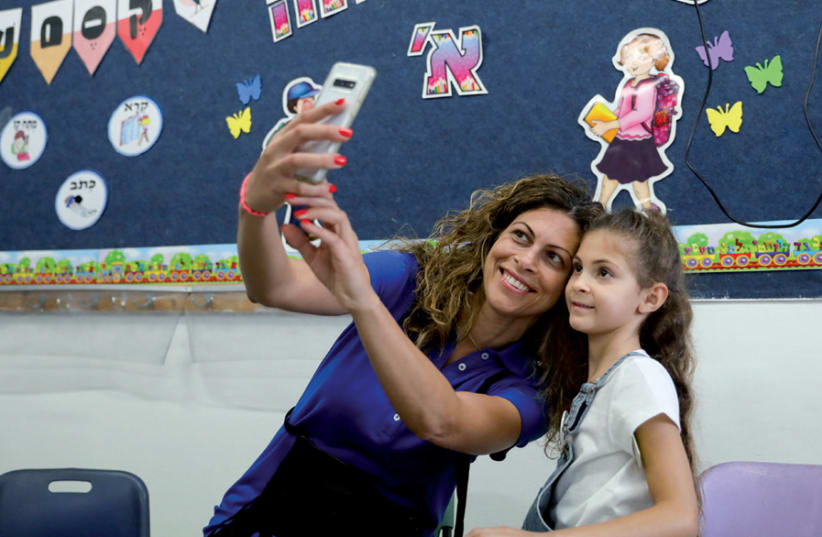 A mother takes a selfie with her first-grade daughter on the first day of school (photo credit: MARC ISRAEL SELLEM)