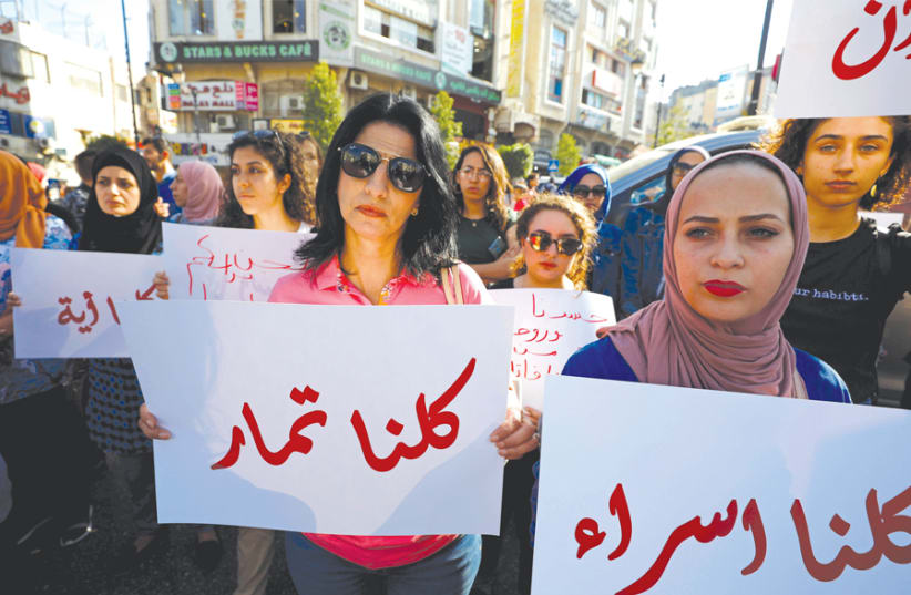 A DEMONSTRATOR holds a banner demanding legal protection for women, in Ramallah on September 4. (photo credit: MOHAMAD TOROKMAN/REUTERS)