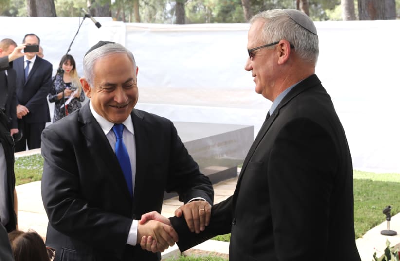 Prime Minister Benjamin Netanyahu shaking hands with Blue and White leader Benny Gantz at a memorial service honoring Shimon Peres (photo credit: MARC ISRAEL SELLEM)