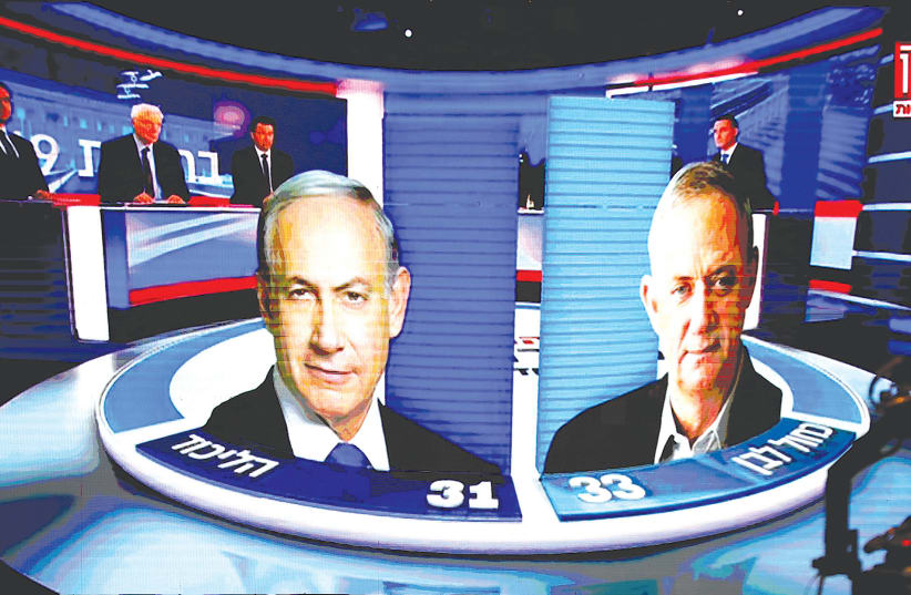 Exit poles used by Channel 13 showing the number of seats won by Likud and Blue and White September 17  (photo credit: AMIR COHEN/REUTERS)