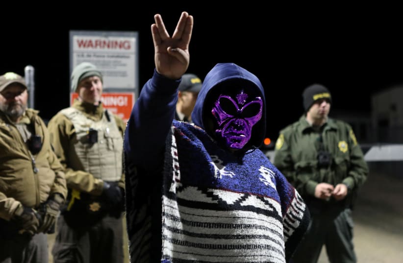An attendee wears an alien mask at the gate of Area 51 as an influx of tourists are expected, responding to a call to 'storm' the secretive U.S. military base, believed by UFO enthusiasts to hold government secrets about extra-terrestrials, in Rachel, Nevada, September 20, 2019 (photo credit: JIM URQUHART/REUTERS)