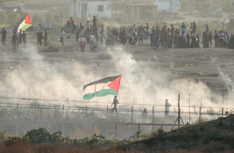 Palestinians riot in front of the Bureij refugee camp, in the central Gaza Strip. IDF troops use tear gas in an attempt to deter them from getting close to the fence. Gaza envelope, Aug 2, 2019 (photo credit: KOBI RICHTER/TPS)