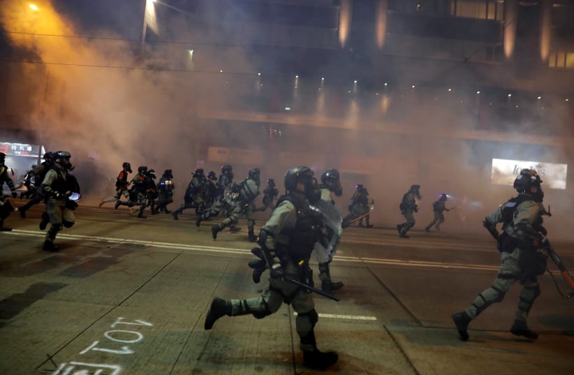 Riot police chase away anti-government protesters near Causeway Bay metro station, after leader Carrie Lam announced emergency laws that would include banning face masks at protests, in Hong Kong, China October 4, 2019 (photo credit: REUTERS/SUSANA VERA)