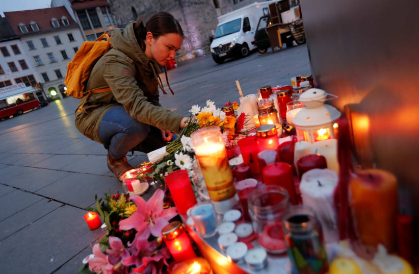 People place candles at central market square in Halle, Germany October 10, 2019, after two people were killed in a shooting (photo credit: REUTERS/FABRIZIO BENSCH)