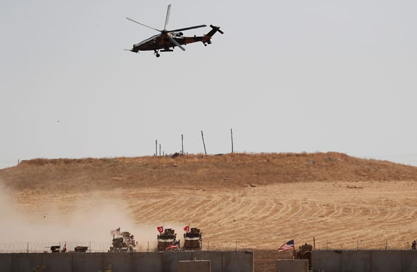 A Turkish military helicopter flies over as Turkish and U.S. troops return from a joint U.S.-Turkey patrol in northern Syria, as it is pictured from near the Turkish town of Akcakale, Turkey, September 8, 2019 (photo credit: REUTERS/MURAD SEZER)
