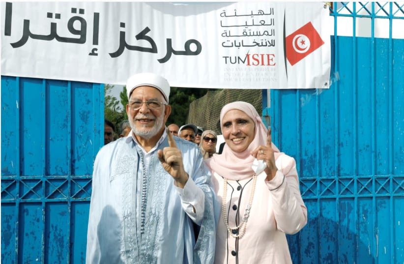 ABDELFATTAH MOUROU of the Ennahda Party and his wife show off their ink-stained fingers after casting their vote at a polling station during the presidential election, in Tunis on September 15. (Zoubeir Souissi/Reuters) (photo credit: ZOUBEIR SOUISSI / REUTERS)