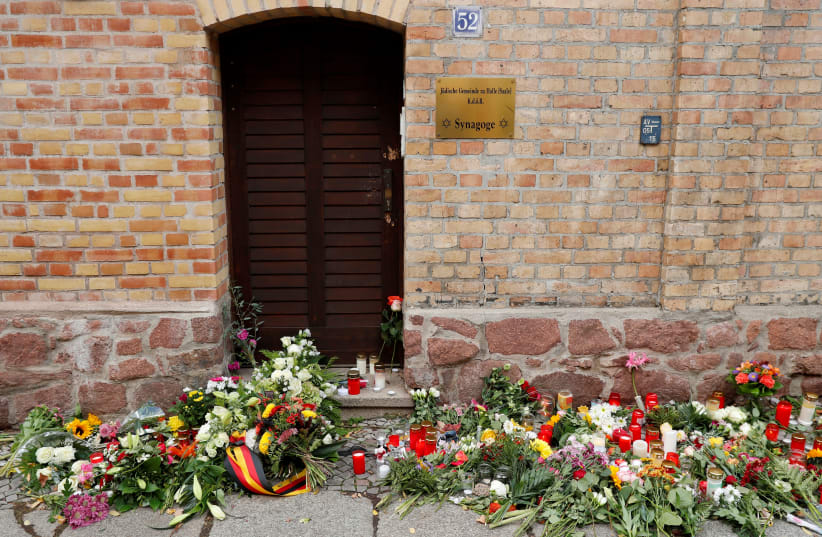 Flowers and candles are seen outside the synagogue in Halle, Germany October 10, 2019, after two people were killed in a shooting (photo credit: REUTERS/FABRIZIO BENSCH)