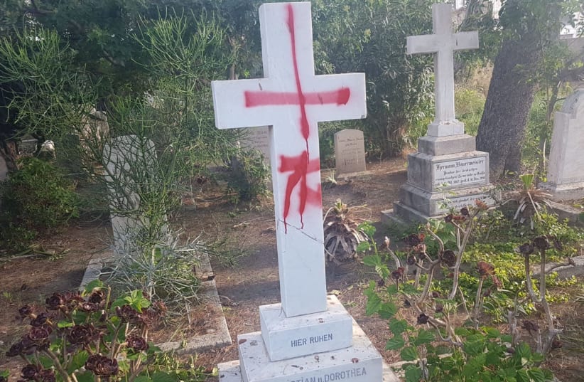 Tombstones desecrated with graffiti at the British cemetery in Haifa (photo credit: POLICE SPOKESPERSON'S UNIT)