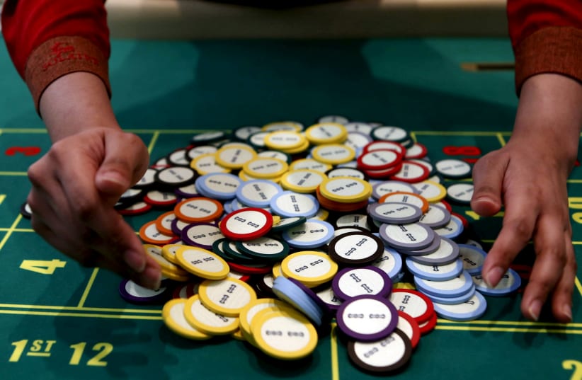 A casino dealer collects chips at a roulette table in Pasay city, Metro Manila (photo credit: ERIK DE CASTRO/ REUTERS)