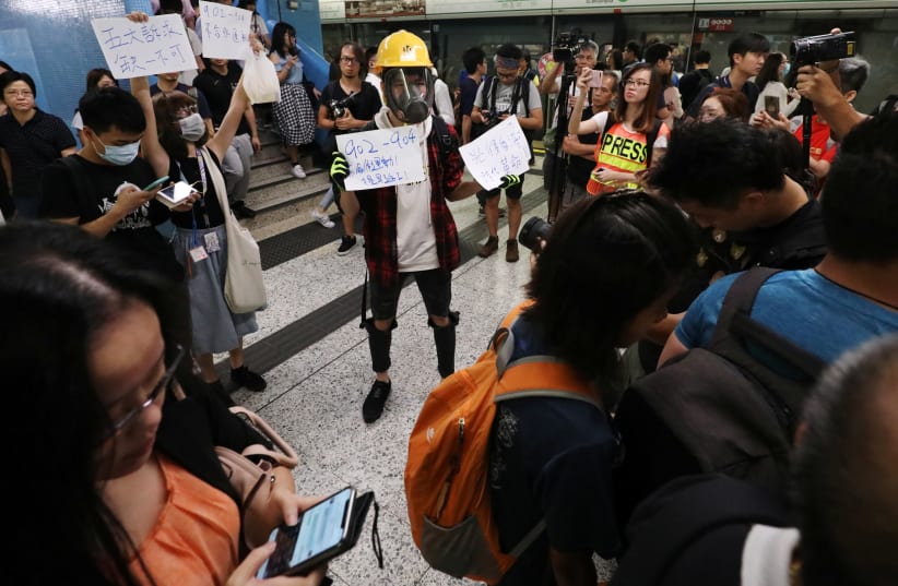 Protesters call people to join further rallies against the government at Kowloon Tong subway station in Hong Kong, China, August 21, 2019 (photo credit: ANN WANG/REUTERS)