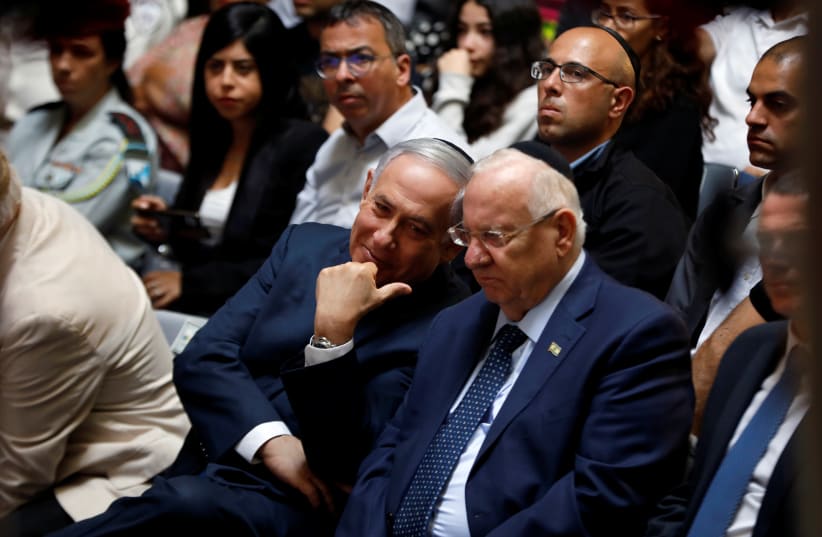 Israeli Prime Minister Benjamin Netanyahu chats with Israeli President Reuven Rivlin during a memorial ceremony for Israeli soldiers killed in the 1973 Middle East War at Mount Herzl Military Cemetery in Jerusalem October 10, 2019 (photo credit: REUTERS/Ronen Zvulun)