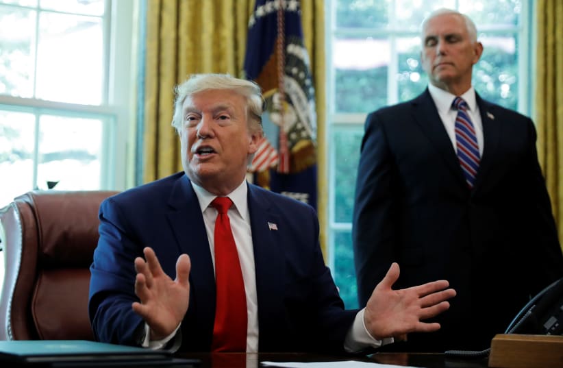 U.S. President Donald Trump talks about the United States imposing fresh sanctions on Iran as Vice President Mike Pence looks on in the Oval Office of the White House in Washington, U.S., June 24, 2019 (photo credit: REUTERS/CARLOS BARRIA)
