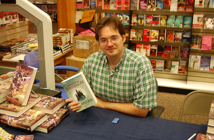 Brandon Sanderson holding a German-language copy of his fantasy novel Elantris on August 18, 2007 at the book pre-release event for Mistborn: The Well of Ascension at the Waldenbooks store in the Provo Towne Centre mall in Provo, Utah. (photo credit: Wikimedia Commons)
