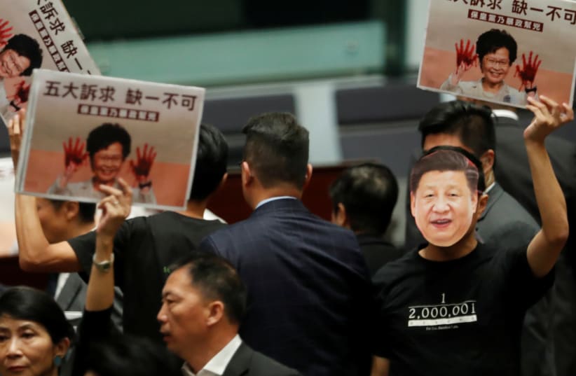 Lawmakers protest as Hong Kong Chief Executive Carrie Lam attempts to deliver her annual policy address, at the Legislative Council in Hong Kong, China, October 16, 2019 (photo credit: REUTERS/KIM KYUNG-HOON)