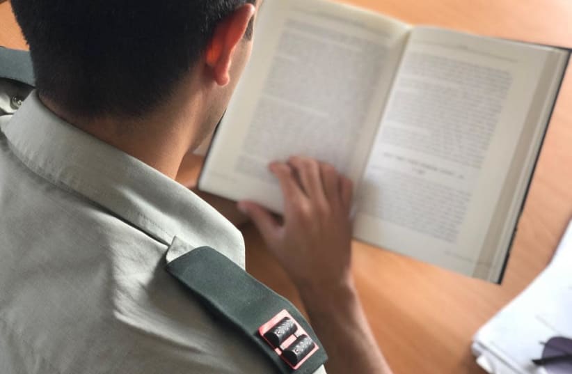 IDF officer reads a book as required by the new army law implemented by Chief of Staff Aviv Kochavi. (photo credit: IDF SPOKESPERSON'S UNIT)