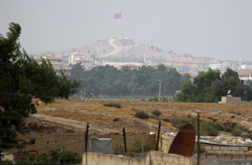 A Turkish flag flies as seen from near Ras al Ain Town, Syria October 19, 2019. Picture taken October 19, 2019 (photo credit: ABOUD HAMAM / REUTERS)