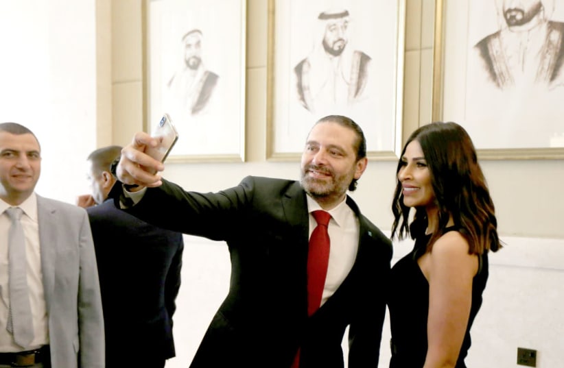 LEBANESE PRIME MINISTER SAAD HARIRI takes a selfie with a participant at the UAE-Lebanon Investment Forum in Abu Dhabi, UAE, on October 7.  (photo credit: SATISH KUMAR/REUTERS)