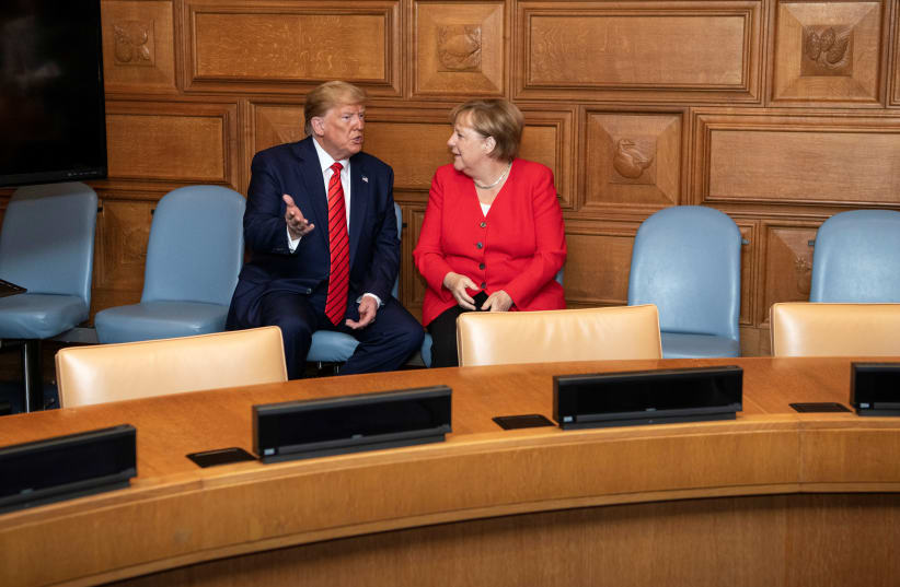 U.S. President Donald Trump talks to German Chancellor Angela Merkel at the U.N. headquarters in New York City, New York, U.S., September 24, 2019 (photo credit: GUIDO BERGMANN/BUNDESREGIERUNG/HANDOUT VIA REUTERS)