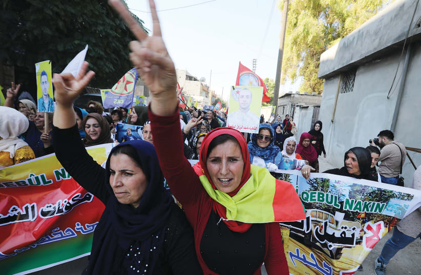 KURDISH AND ARAB protesters chant slogans against Turkish President Tayip Erdogan in Qamishli, Syria, Wednesday. (photo credit: MOHAMMAD HAMED / REUTERS)