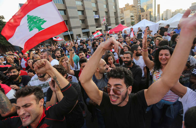 Protestors celebrate after Lebanon's Prime Minister Saad al-Hariri announced his resignation in Beirut, Lebanon October 29, 2019 (photo credit: AZIZ TAHER/REUTERS)