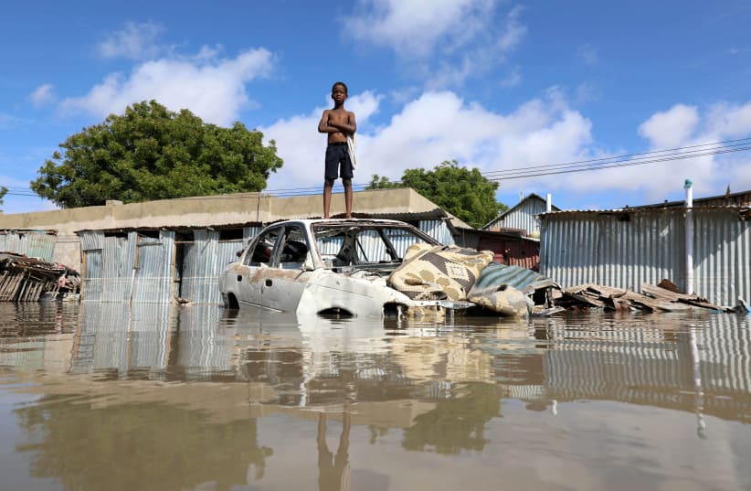 A Somali boy stands on a junk vehicle after heavy rain flooded their neighbourhood in Mogadishu (photo credit: FEISAL OMAR/REUTERS)