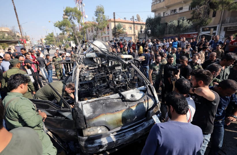 Members of the Syrian regime inspect the location where a car bomb exploded in the northeastern Syrian town of Qamishli which is mainly controlled by Kurdish forces, Syria October 23, 2019 (photo credit: MOHAMMAD HAMED / REUTERS)