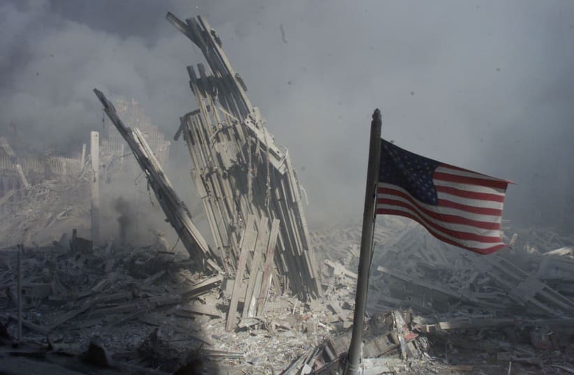 Am American flag flies near the base of the destroyed World Trade Center in New York, September 11, 2001. Planes crashed into each of the two towers, causing them to collapse (photo credit: REUTERS)