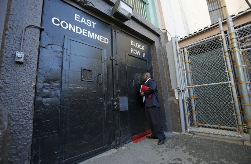 Lieutenant Sam Robinson, a public information officer at San Quentin State Prison, knocks on the door to the East Block for condemned prisoners during a media tour of California's Death Row in San Quentin, California (photo credit: REUTERS)