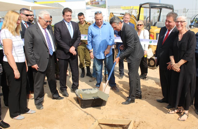 Pastor Jentezen Franklin (center) lays the cement for the cornerstone of the new state-of-the-art educational campus. (photo credit: JNF-USA)