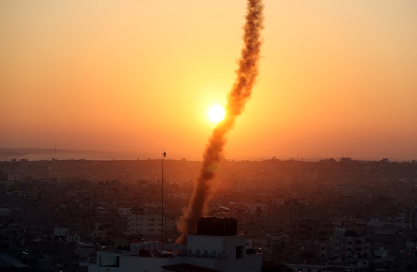 A trail of smoke can be seen as rockets are fired from Gaza towards Israel (photo credit: REUTERS/MOHAMMED SALEM)