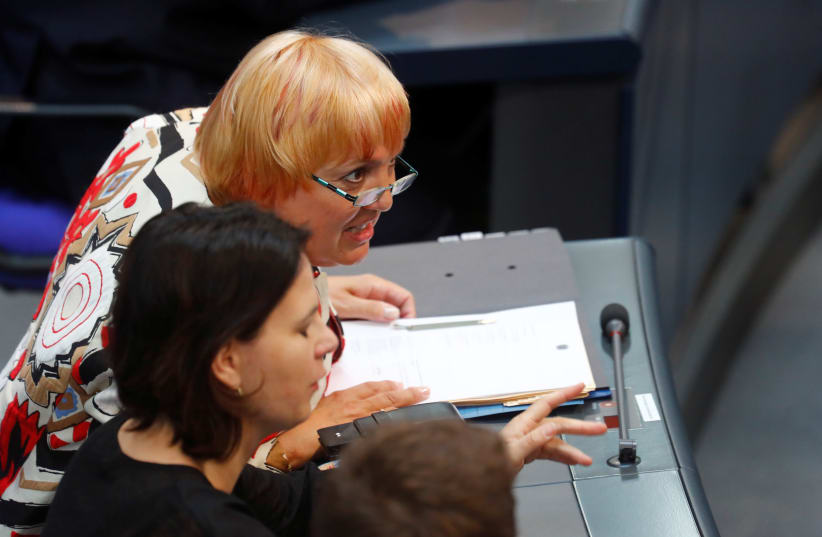 Katrin Goering-Eckardt and Claudia Roth from the Greens party react during the 2018 budget debate at the lower house of parliament Bundestag in Berlin, Germany, May 16, 2018 (photo credit: REUTERS/HANNIBAL HANSCHKE)