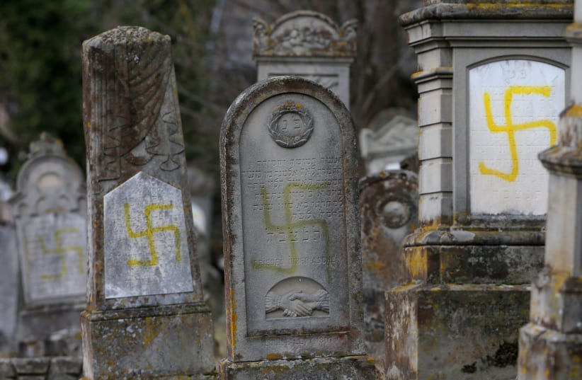 Graves that were desecrated with swastikas are seen at the Jewish cemetery in Quatzenheim, France.  (photo credit: VINCENT KESSLER/ REUTERS)