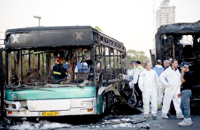 Police forensic experts work at the scene of a terrorist bombing attack in Talpiot, Jerusalem on April 18, 2016. An explosion tore through a bus and set a second bus on fire, wounding 21 people, two critically.  (photo credit: RONEN ZVULUN / REUTERS)