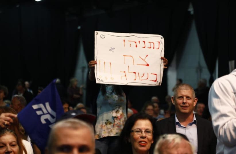 'Netanyahu is pure as snow,' a banner held by a Likud supporter at an emergency rally says  (photo credit: AVRAHAM SASSONI)