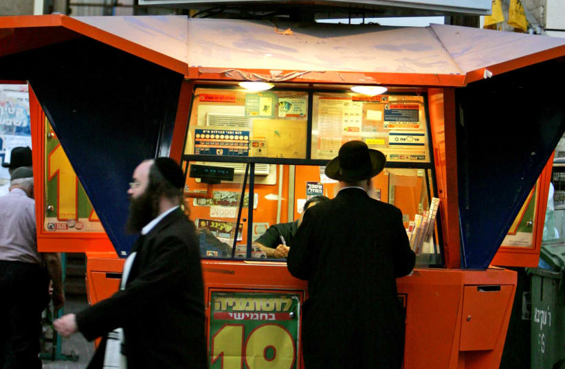 An Ultra orthodox Jewish man stands in front of a lottery station in Bnei Brak city, near Tel Aviv, September 28, 2005. (photo credit: GIL COHEN MAGEN)