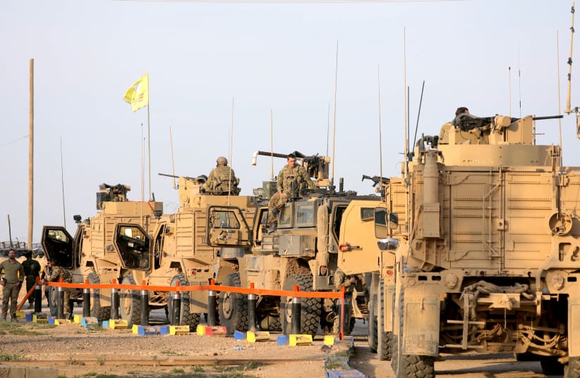 AMERICAN SOLDIERS stand near military trucks at al-Omar oil field in Deir Al Zor, Syria, on March 23.  (photo credit: REUTERS)