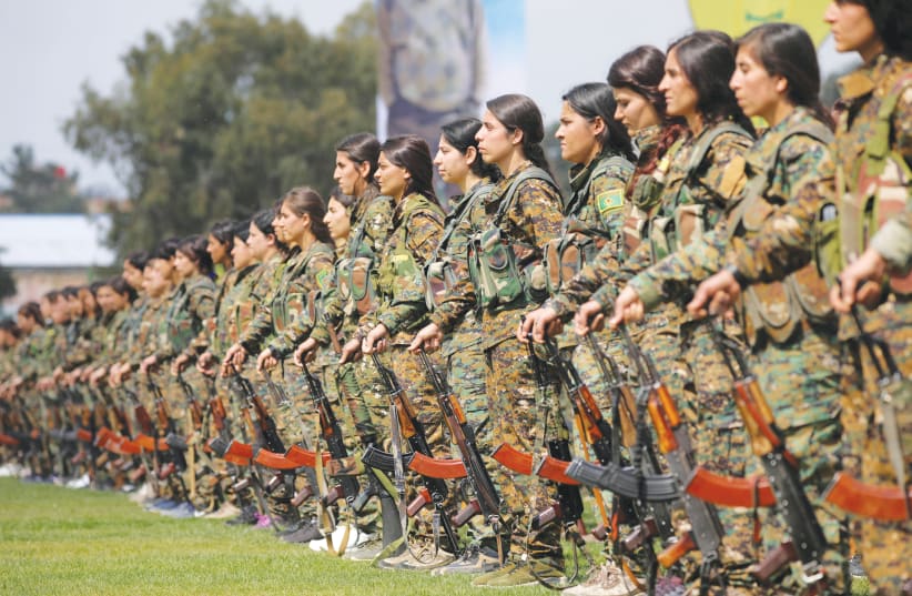 KURDISH FEMALE fighters of the Women’s Protection Unit (YPJ) take part in a military parade as they celebrate victory over the Islamic state, in Qamishli (photo credit: REUTERS)