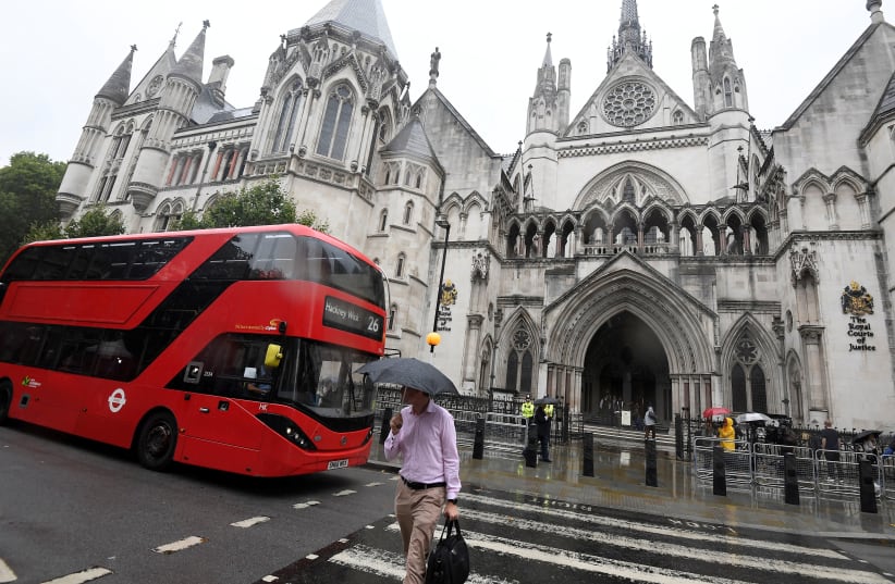 A London bus is driven past The Royal Courts of Justice in London, Britain, July 30, 2019 (photo credit: REUTERS/TOBY MELVILLE)