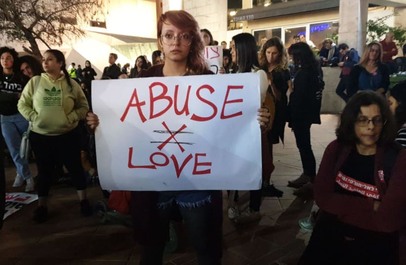 A protester holding an "Abuse isn't Love" sign at a protest against violence against women in Tel Aviv (photo credit: TAMAR BEERI)