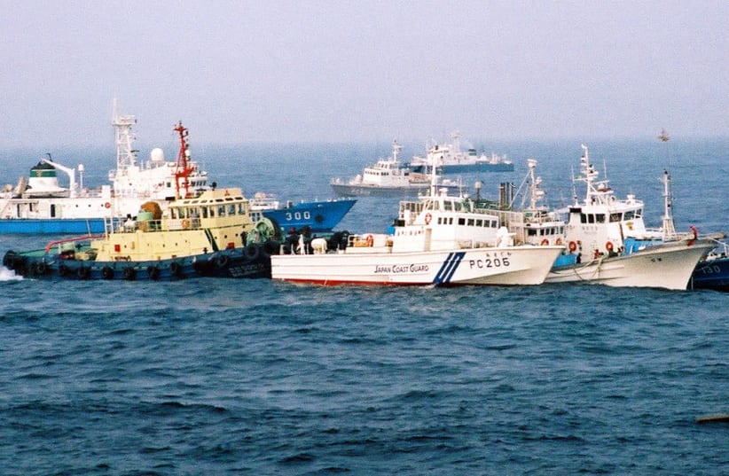 South Korean police stand guard on their patrol ship next to a South Korean fishing boat and a Japanese patrol boat on the sea off Ulsan. South Korean police stand guard on their patrol boat (R), next to a South Korean fishing boat (2nd R) and a Japanese coast guard vessel (3rd R), on the sea off Ul (photo credit: REUTERS)