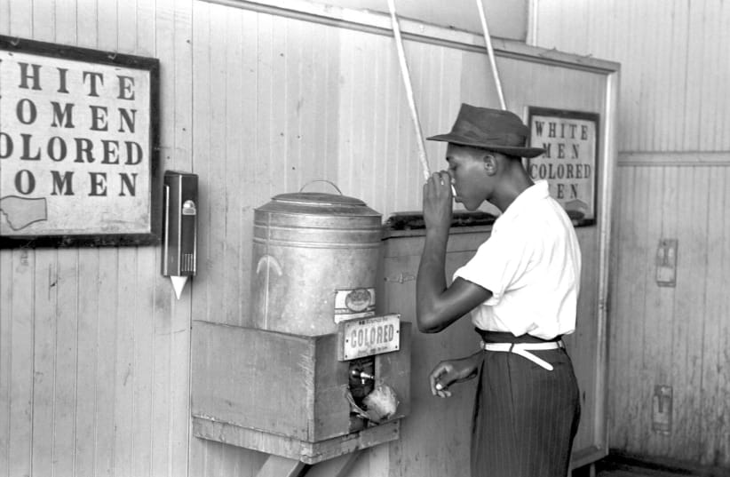 AN AFRICAN AMERICAN uses a ‘colored’ water fountain in Segregation-era American South. (photo credit: PIXABAY)