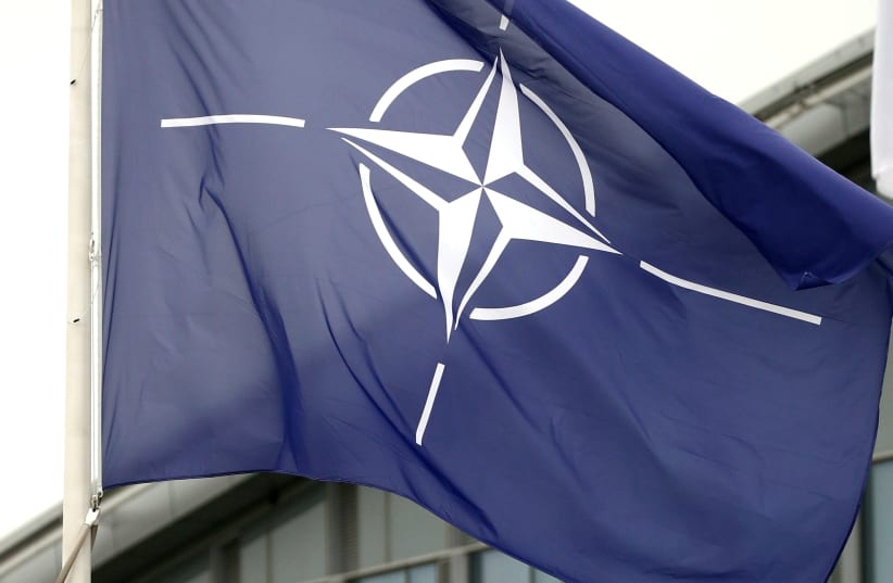 NATO flag flutters at the Alliance headquarters in Brussels, Belgium, (photo credit: REUTERS/FRANCOIS LENOIR)