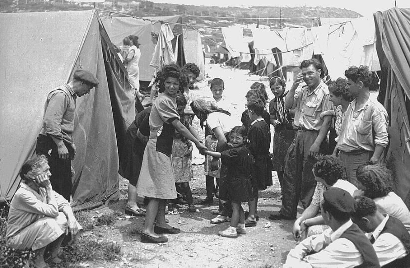 Iraqi Jewish refugees stand in a refugee absorption camp. established in Israel in 1950. (photo credit: Wikimedia Commons)