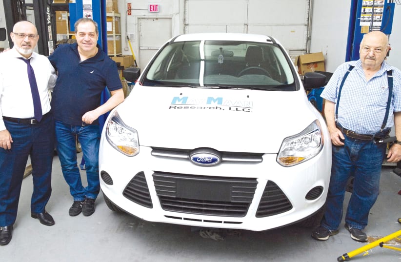 YEHUDA SHMUELI and his sons, Eitan and Doron with the car prototype  (photo credit: DANIEL GODOY)