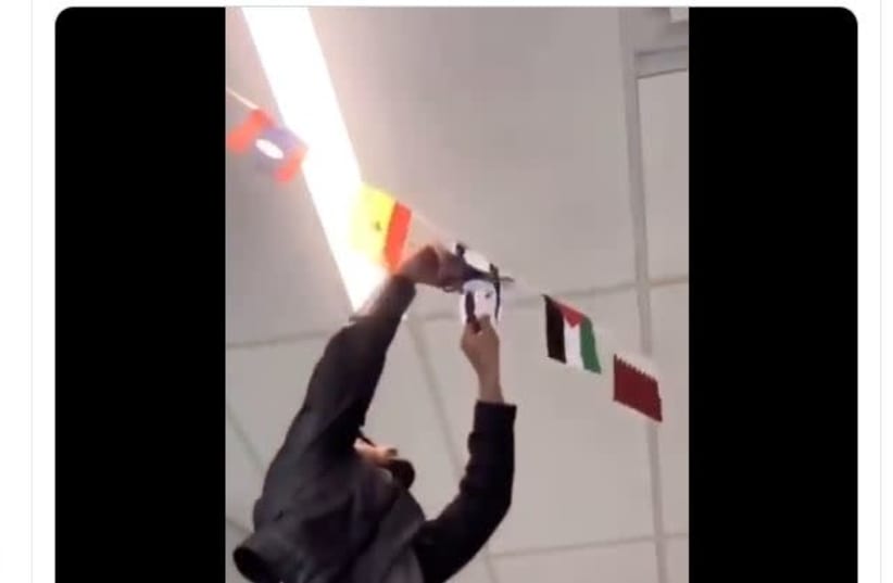 A Columbus State Community College student cuts an Israeli flag off an international flag display (photo credit: screenshot)