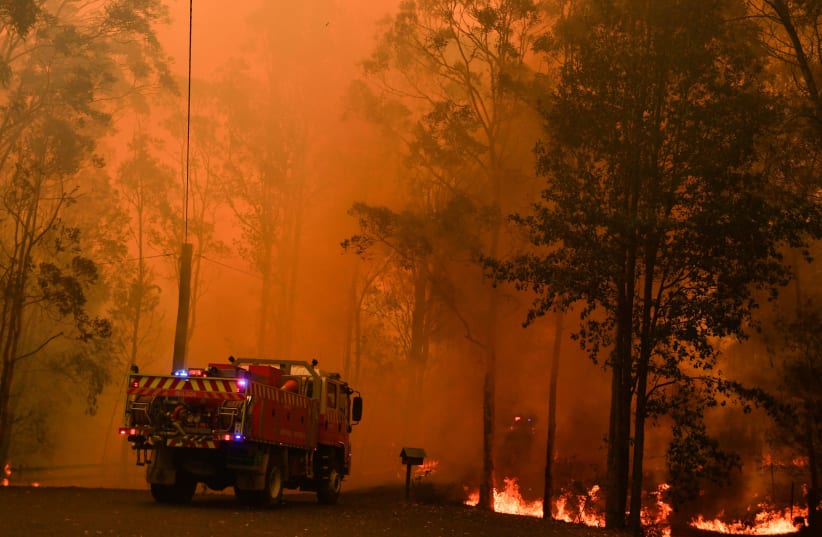 Fire trucks are seen during a bushfire in Werombi, 50 km southwest of Sydney, Australia. (photo credit: AAP IMAGE/MICK TSIKAS/VIA REUTERS)