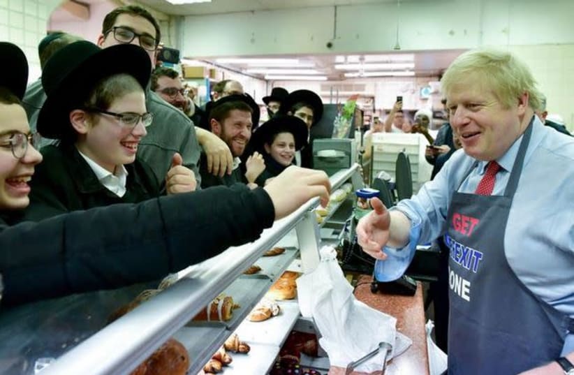 PM Boris Johnson visits Grodzinski bakery wearing 'Get Brexit Done' apron on December 6 , 2019  (photo credit: Courtesy)