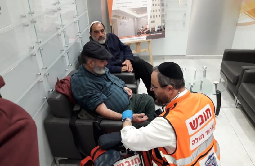 David Ben Avraham is treated by a paramedic following his release from jail, while friend Haim Pereg sits by.  (photo credit: COURTESY UNITED HATZALAH)