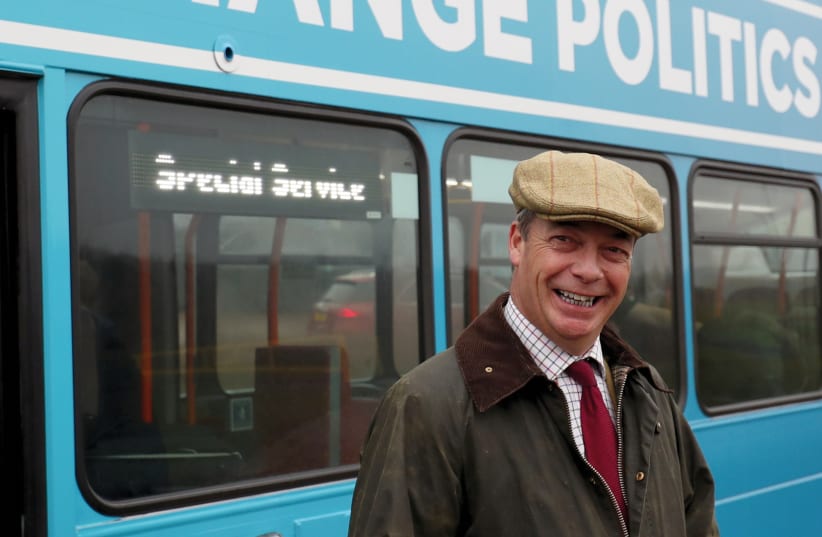 Brexit Party leader Nigel Farage stands outside his battle bus during an election campaign event in Easington, Britain, on November 24 (photo credit: REUTERS)